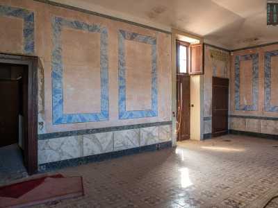 In una di queste, con cornici celesti sui muri ad effetto marmo...